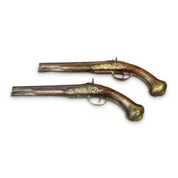 Paire de pistolets richement sculptée et ornée de laiton niellé.