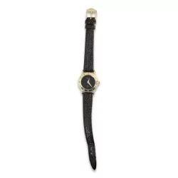 \"Gucci\" watch with a gold-colored case and a black leather strap.