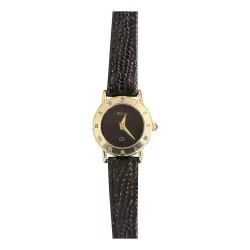\"Gucci\" watch with a gold-colored case and a black leather strap.