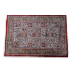 Tapis Iranien en soie. Coloris blanc, rouge, noir et vert.