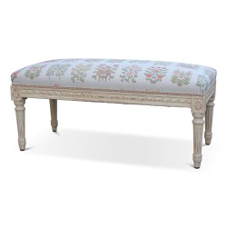 A richly carved Louis XVI bench, painted wood. Upholstered in floral lampas fabric.