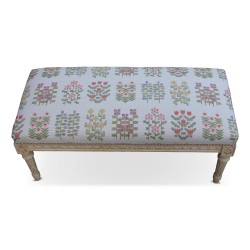 A richly carved Louis XVI bench, painted wood. Upholstered in floral lampas fabric.