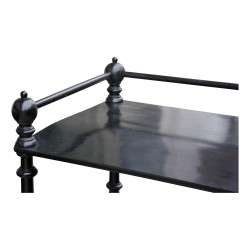 A black turned wooden shelf on wheels.