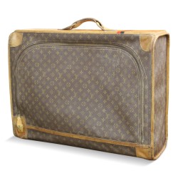 Valise "Louis Vuitton" recouvert de tissu imprimé et de cuir marron.