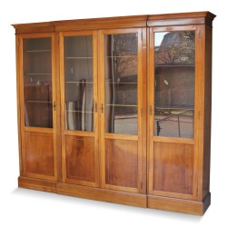 Bibliothèque en acajou montée sur chêne. Quatre portes vitrées. Paris. Vers 1950.