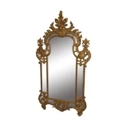 Miroir de style Régence en bois sculpté et doré.