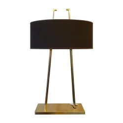 “Estro” lamp with golden base and black lampshade.