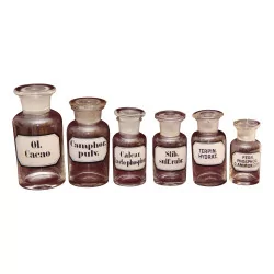 Series of glass medicine bottles with caps. Era : …