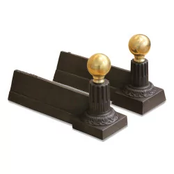 A pair of cast iron and bronze andirons
