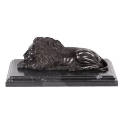 Statuette of a burnished bronze lion on a marble base (left).