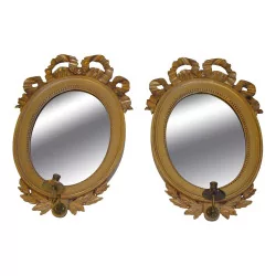 Paire de miroirs Louis XVI doré à l'or fin de forme ovales.