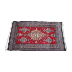 Oriental rug in red with white fringes. 20th …