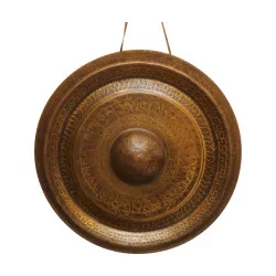 个圆形藏式铜锣，挂在带有……的生锈青铜中