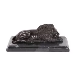Statuette of a burnished bronze lion on a marble base (left).