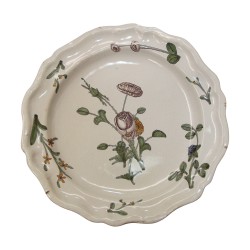 Assiette en faïence à bord contourné à décor polychrome d'une …