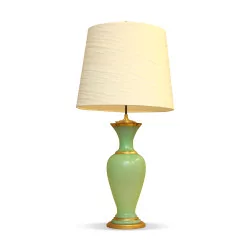 Лампа установлена на зеленой опаловой вазе с золотыми нитями.