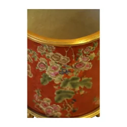 Cache-pot avec motif floraux sur fond rouge foncé.