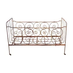 生锈的锻铁婴儿床。床上用品：长 138 x 深 58 厘米