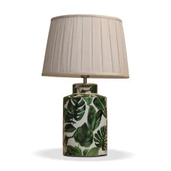 Lampe de table en céramique avec décors de feuilles exotiques.