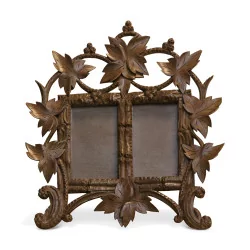 Double carved wooden frame decorated with vine leaves. …