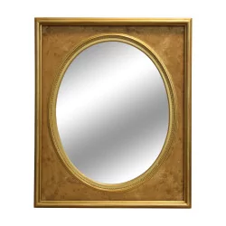 Miroir ovale avec un cadre en bois doré.