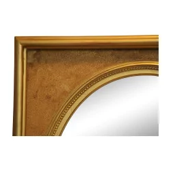 Miroir ovale avec un cadre en bois doré.