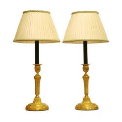 pair of candlestick lamps in gilt and chiseled bronze, with …