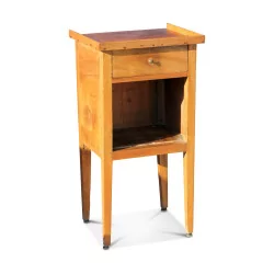 A walnut bedside table with a drawer and a niche.