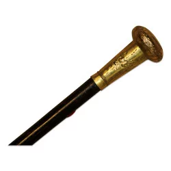 Cane with a round handle in engraved metal.