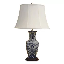 Chinese blue and white porcelain lamp, floral pattern with a wooden foot. White empire lampshade and satin finial.