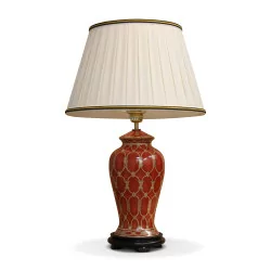 A red and gold ceramic lamp with wooden base