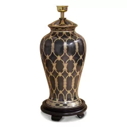 black and gold ceramic lamp with a wooden foot and white empire lampshade with black and yellow border.