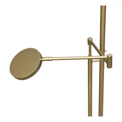 A brass LED floor lamp with its reading arm
