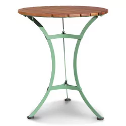 A round garden table with green metal legs