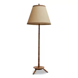 A tripod floor lamp with beige shade