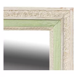 Ein Spiegel mit Holzrahmen und weißer und grüner Patina