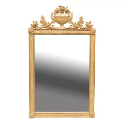 A carved and gilded wooden mirror in the Louis XVI style