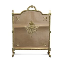 A richly sculpted Louis XVI gilt bronze ribbon fire screen