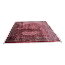 Grand tapis d'orient dans les tons rouges.