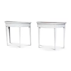 A pair of half-moon tables in white painted wood