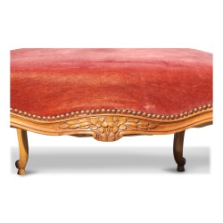 A molded walnut seat with pink velvet
