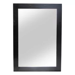 Ein Spiegel mit einem schwarz lackierten Holzrahmen