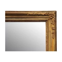 Ein Spiegel mit einem reich geformten vergoldeten Rahmen