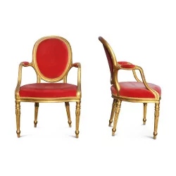 A pair of gilded wood seats covered in red velvet