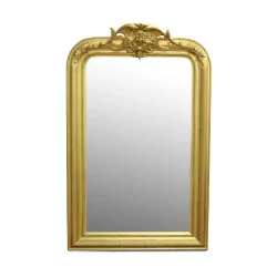 A mirror with a richly molded gilded frame