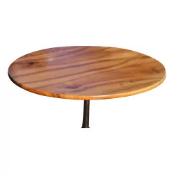 A circular walnut table, cast iron tripod foot