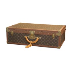 Un bagage "Louis Vuitton" recouvert de cuir imprimé, orné de laiton doré