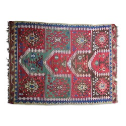 Ein Kelim-Teppich aus Wolle in Grün, Rot, Blau, Schwarz und Weiß.