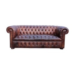 A “Chesterfield” sofa in leather, brown patina. Restored