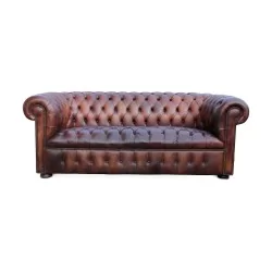 Un canapé "Chesterfield" en cuir, patine marron. Restauré